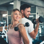 Homem e mulher fazendo exercício com haltere