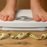 uma pessoa se pesando e uma fita métrica para representar calculadora de peso ideal