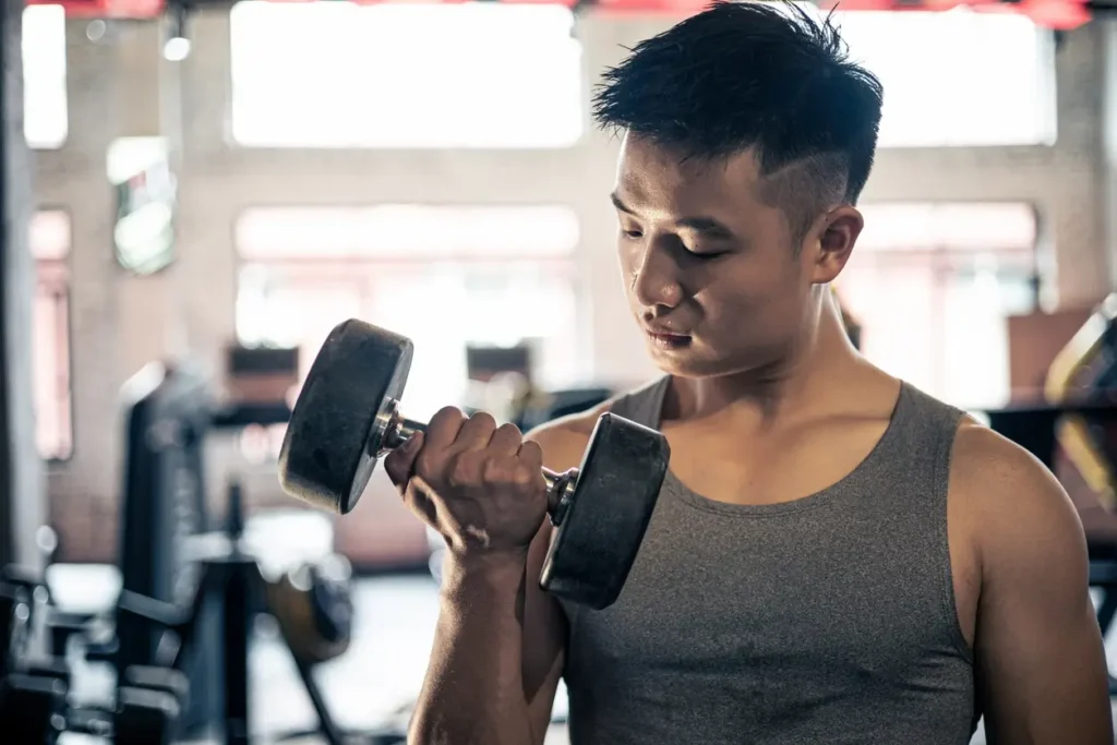 homem fazendo exercício com haltere para representar cardio ou muscculação