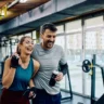 homem e mulher sorrindo na academia para representar calculadora de creatina por peso